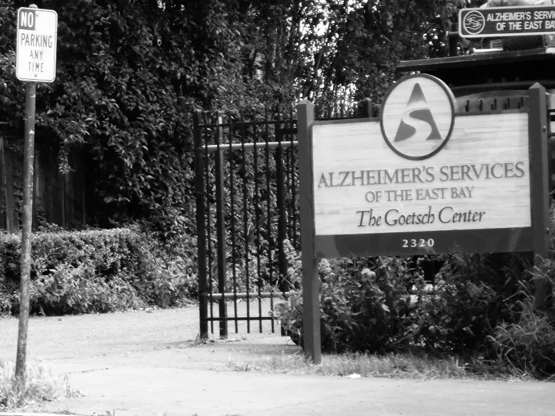 There is a No Parking sign outside the Alzheimer's Services of the East Bay. This image is in greyscale for dramatic effect.