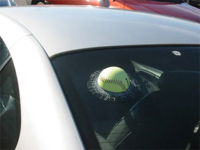 A fake baseball glued onto a car windshield.