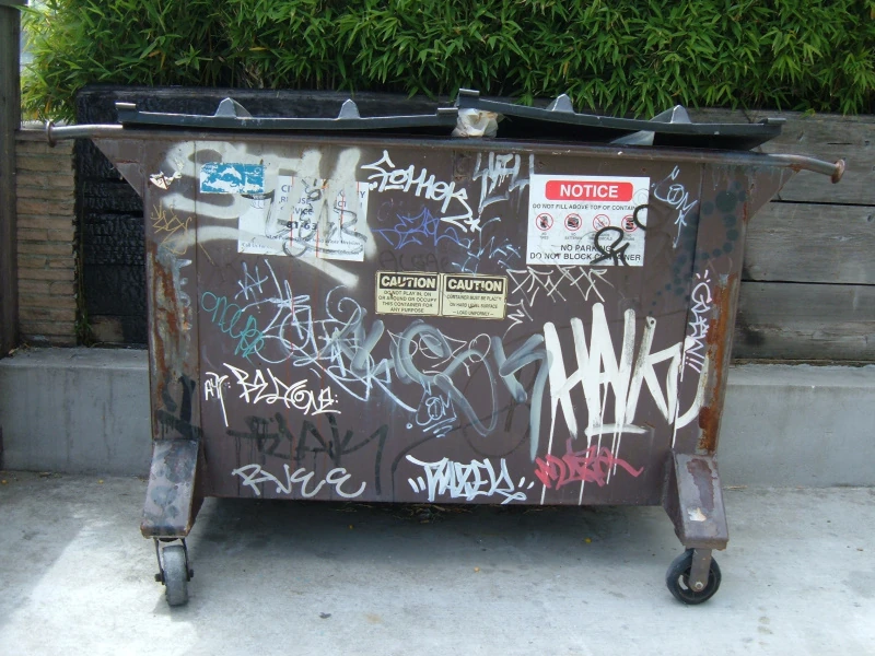 A heavily vandalized Dumpster.
