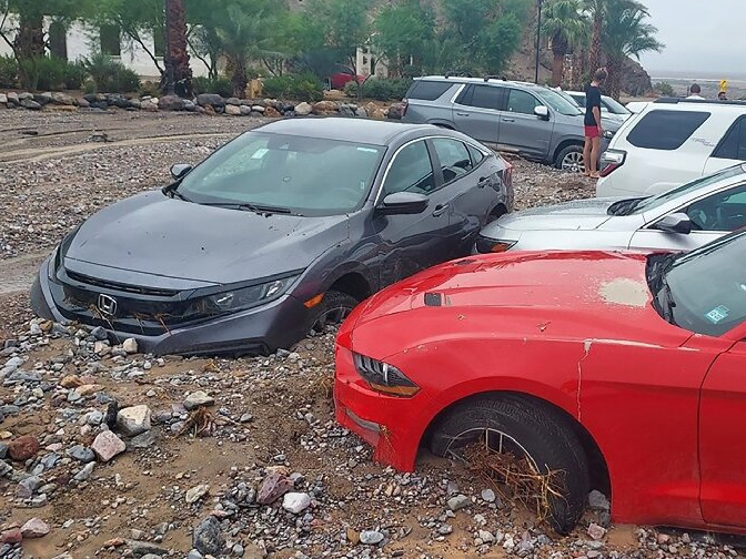 A handful of cars half-buried in the ground.