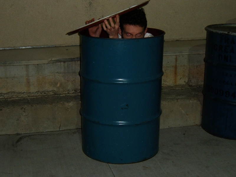 A barrel with an open lid and Josh inside.