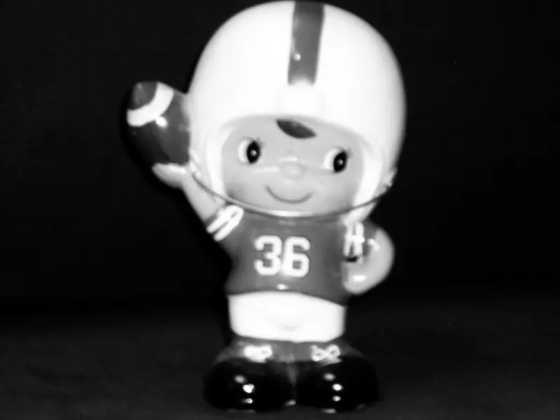A greyscale ceramic football player made scary.